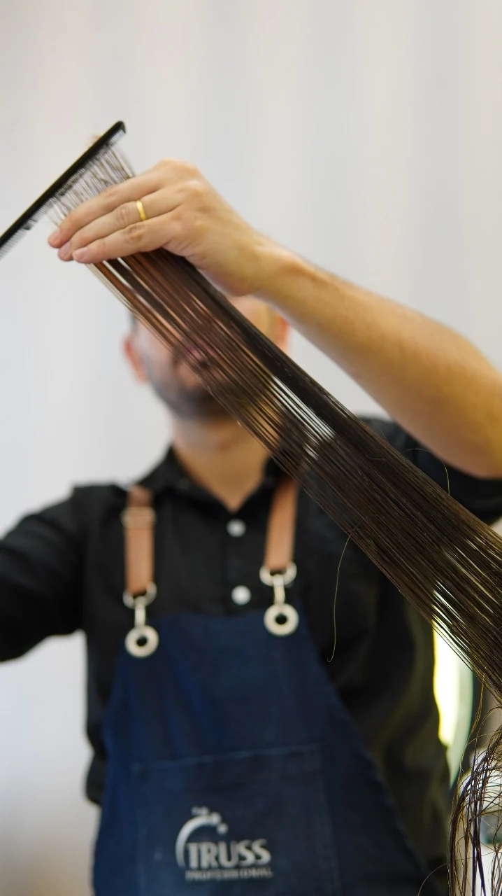 Profissional cortando o cabelo de uma cliente no Studio L